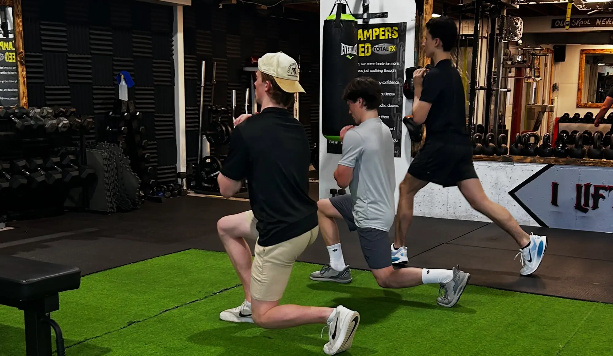 Two athletes squatting on the turf during a session at K2 Athletics in Charlottetown
