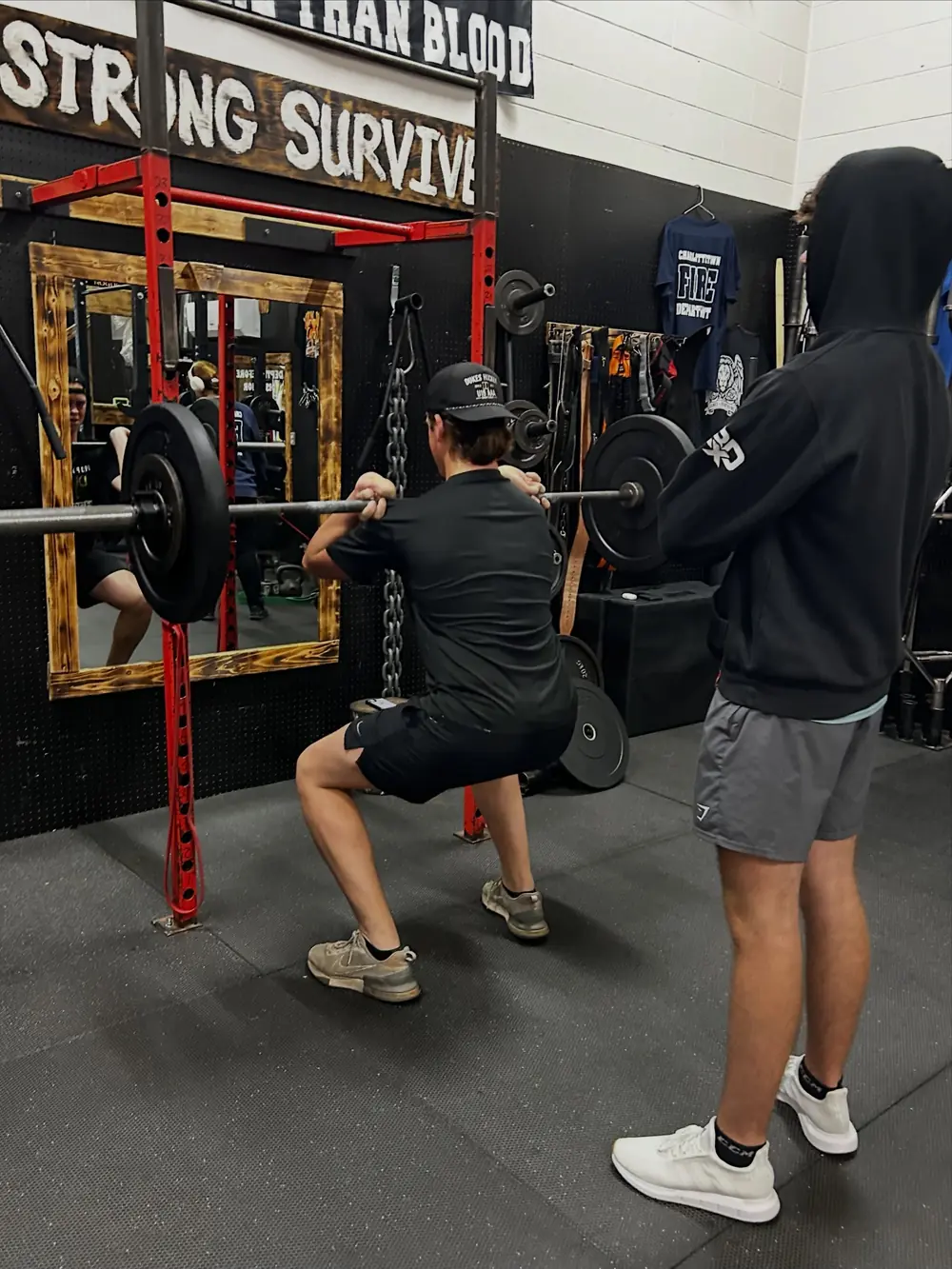 Kyle spotting an athlete through a squat