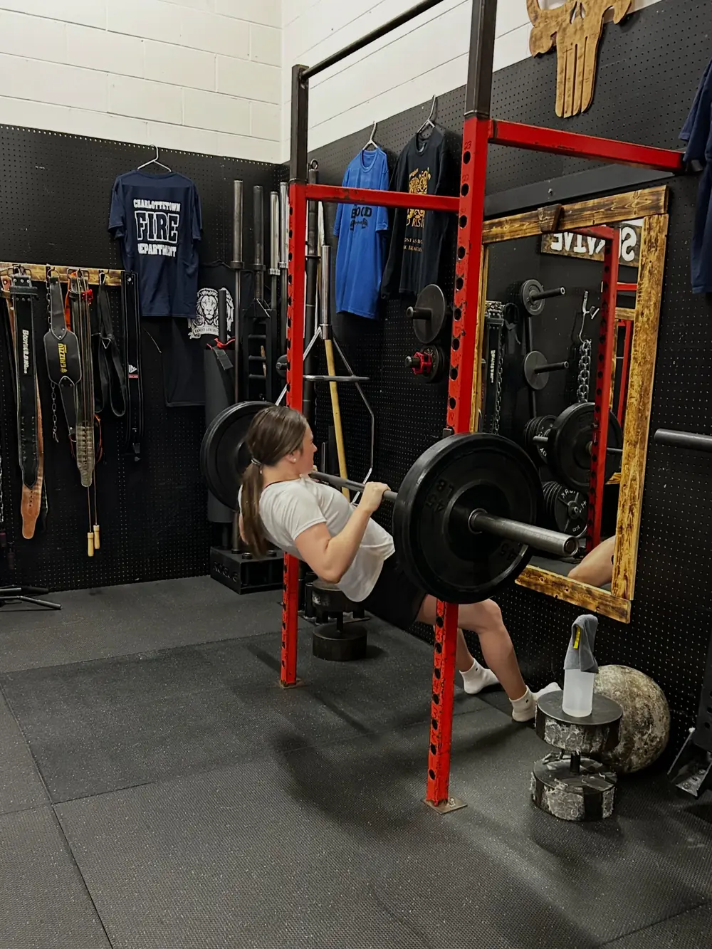 A young athlete front squatting in the rack during a K2 summer session