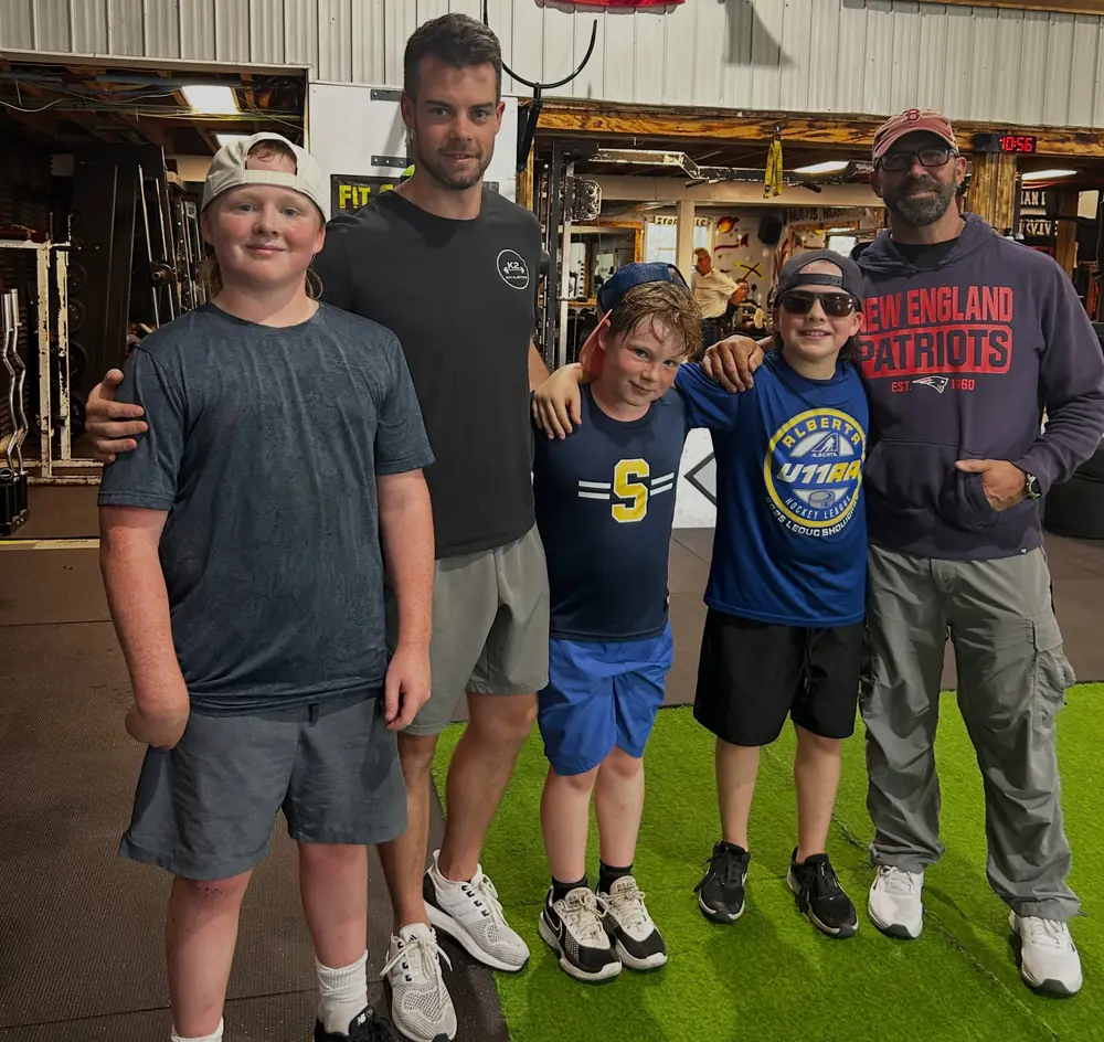 A group of young athletes with their coaches after a summer session